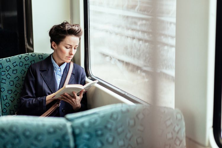 Woman reading a book on a train